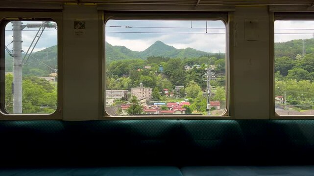 Stunning scenery rolling outside train window in Japan passing through rural countryside