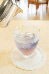 バタフライピーのアイスハーブティーにシークヮーサー果汁を注ぐ