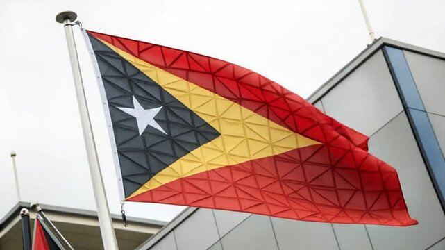 East Timor Flag Waving Dynamically Against Modern Building Backdrop - National Symbol