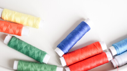 Colorful sewing threads with measuring tape on clean white background