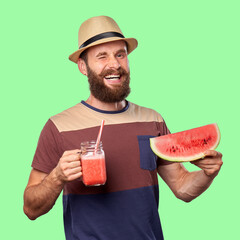Smiling bearded man in hat holding watermelon slice and smoothie against green background. Concept of summer refreshment, healthy lifestyle, and cheerful vacation mood