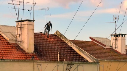 A dedicated worker meticulously cleaning rooftop surfaces, showing great attention to detail