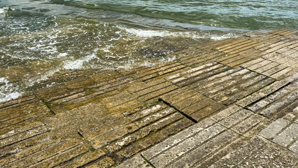 Wave-kissed stone pier, whispering stories of Neptune's trident, ideal for Nautical Archaeology Day...