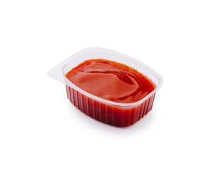 Bright red condiment in a small plastic container for savory dishes
