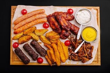 Delicious barbecue platter featuring sausages, chicken wings, and sides