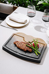 Grilled steak served on a sizzling stone platter in outdoor dining setting