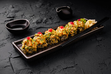 Sushi platter with colorful toppings served on a dark stone background