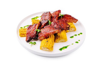 Grilled ribs served with sweet corn and green sauce for a summer meal