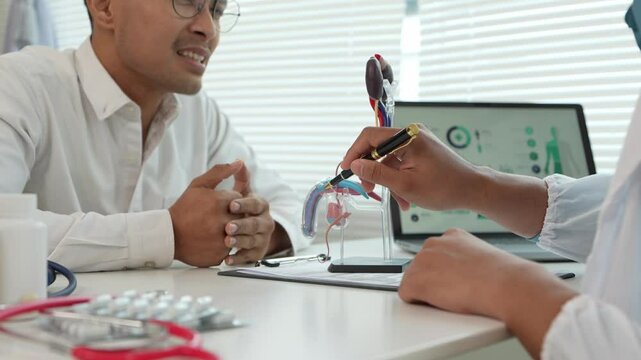 A male patient with a urinary tract infection visits a doctor at a hospital examination table to discuss his symptoms. Talk about an enlarged prostate.
