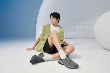 Young Asian male sitting in casual sporty attire.