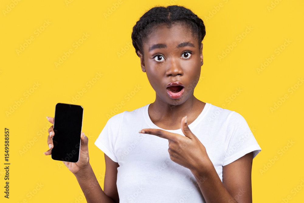 Poster new app. shocked african woman showing phone blank screen to camera recommending mobile application 