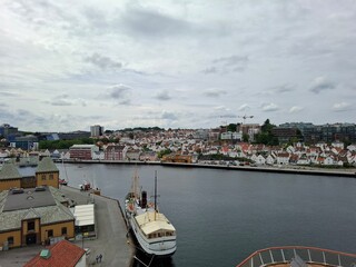 norway stavanger june 14 2024 A large ship is docked at a harbor with a cloudy sky in the background. The scene is peaceful and serene,