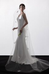 Elegant woman in white wedding dress and veil.