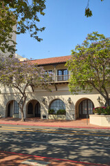 Historic White Building with Arched Entry and Trees

