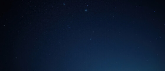 Fototapeta premium Starry night sky with twinkling stars and deep blue background creates serene atmosphere, perfect for stargazing and reflection