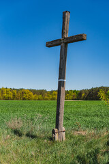Old wooden Christian cross near the field