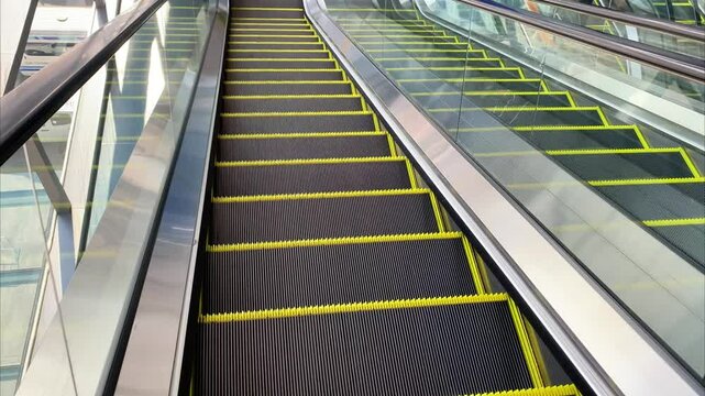 Descending escalator moving down in a modern public space, smooth mechanical motion, urban architecture, transportation concept, daily commute, clean minimal interior