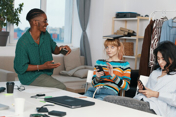 smiling man and young adult woman socializing and working together as coworkers and friends in a...