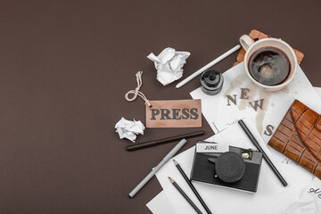 Creative flat lay with vintage camera, press tag, ink bottle, spilled coffee, and messy papers