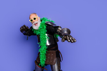 Eccentric knight in full armor and colorful accessories posing against a vibrant purple backdrop
