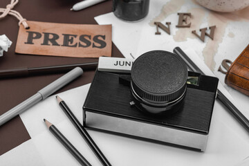 Creative flat lay with vintage camera, press tag, ink bottle, spilled coffee, and messy papers