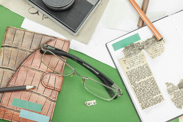 Flat lay with vintage camera, cassette, notebook, key and research tools on green background