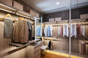 Modern walk-in closet with organized clothes and warm lighting