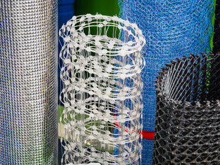 Various types of mesh rolls displayed in a hardware store during daylight hours
