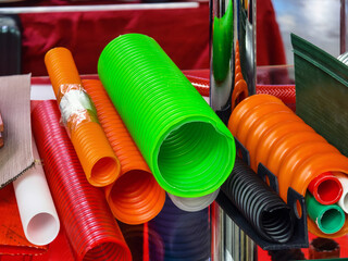 Colorful collection of plastic tubes displayed at a market stall during a sunny afternoon