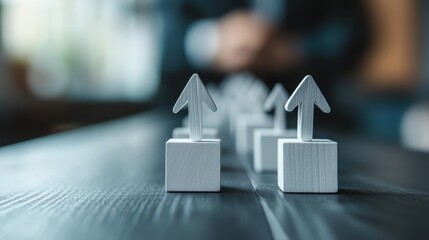A series of upward-pointing arrows arranged neatly on a dark wooden surface, symbolizing growth, progress, and achievement in a structured manner.
