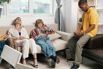 young adult coworkers socializing in casual workplace, Gen Z friends relaxing and working together...