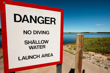 Small boat launch pier on the Rainbow Flowage, Wisconsin River,  near Lake Tomahawk, Wisconsin. Sign states "Danger, No Diving, Shallow Water, Launch Area" and warns of shallow water, though the area 
