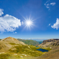 small emerald lake among green mountain valley at the summer sunny day