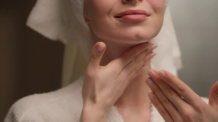 Happy beautiful Caucasian young woman applying body cream rubbing neck skincare gorgeous female model in bath towel bathrobe apply lotion cosmetic massaging soft skin care beauty routine home bathroom - Powered by Adobe