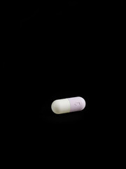 Minimalist alprazolam sedative medication pill on black background