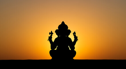 Silhouette of Hindu deity Ganesha at sunset, serene and spiritual.