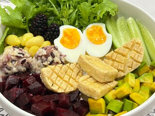 Baked tofu and Soft boiled egg with mixed salad on top with sesame dressing