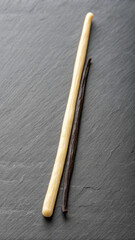 Naklejka premium Two vanilla beans against slate background representing culinary ingredients and flavoring