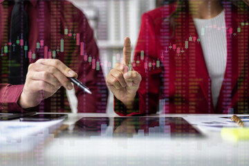 Businesspeople analyzing financial data displayed on a futuristic transparent screen, the integration of technology in modern finance.