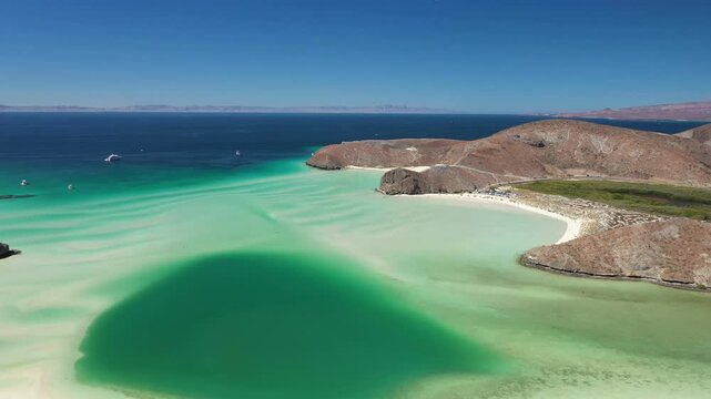 Scenic Balandra beach showcasing turquoise waters and pristine coastline, with tourists enjoying serene landscape near La Paz in Baja California Sur, Mexico