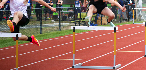 Athletes Hurdling at an Outdoor Track Meet