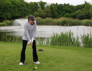 Golf Practice Session by the Serene Pond in a Lush Park Setting