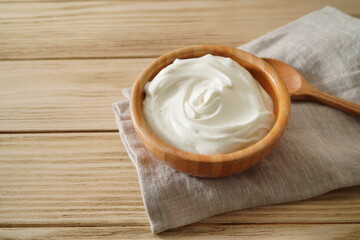 Sour cream in bowl on wooden table. Natural yogurt.