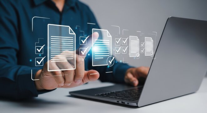 Photo of a man uses a laptop to review and approve digital documents with checkmarks