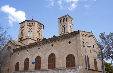 Fototapeta premium Historic stone church with twin towers and intricate architectural details against a clear blue sky