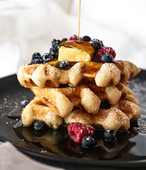 waffles with berries, syrup and butter 