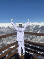 Young Woman in Colorful Ski Outfit Enjoying Scenic Winter Mountain View at Snowy Ski Resort on Vacation