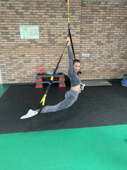 Young Woman in Grey Sportswear Doing Front Split on Tatami Mat in Gym