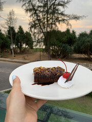 Delicious Chocolate Dessert with Ice Cream Scoop on White Plate &ndash; Gourmet Hotel Treat on Vacation. Appetizing chocolate dessert served with a scoop of vanilla ice cream on a white plate. 