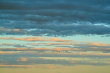 Textured Cumulus congestus illuminated by bright orange-pink light during sunset. A symbol of...